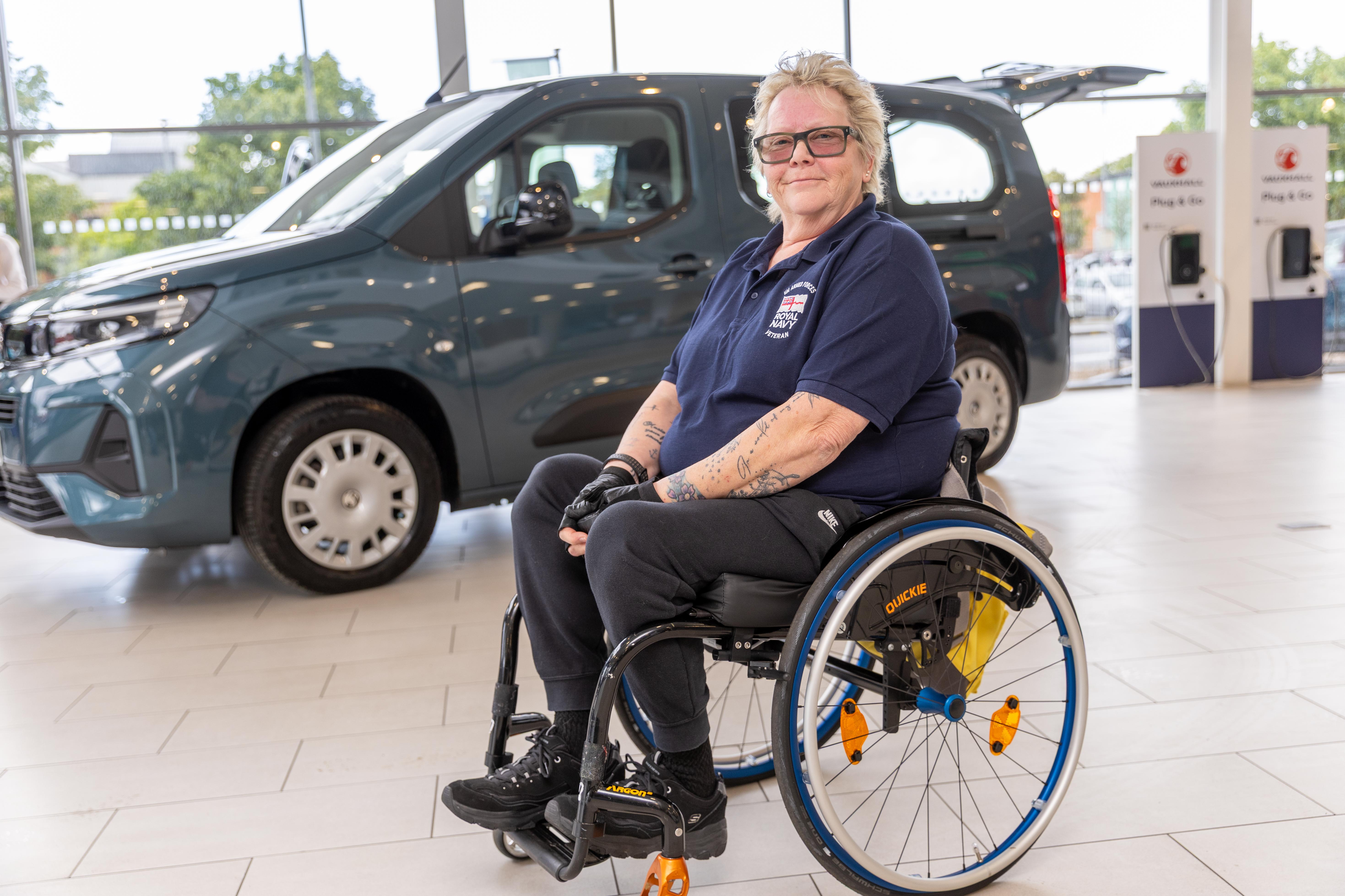 Woman in wheelchair at a car dealership.