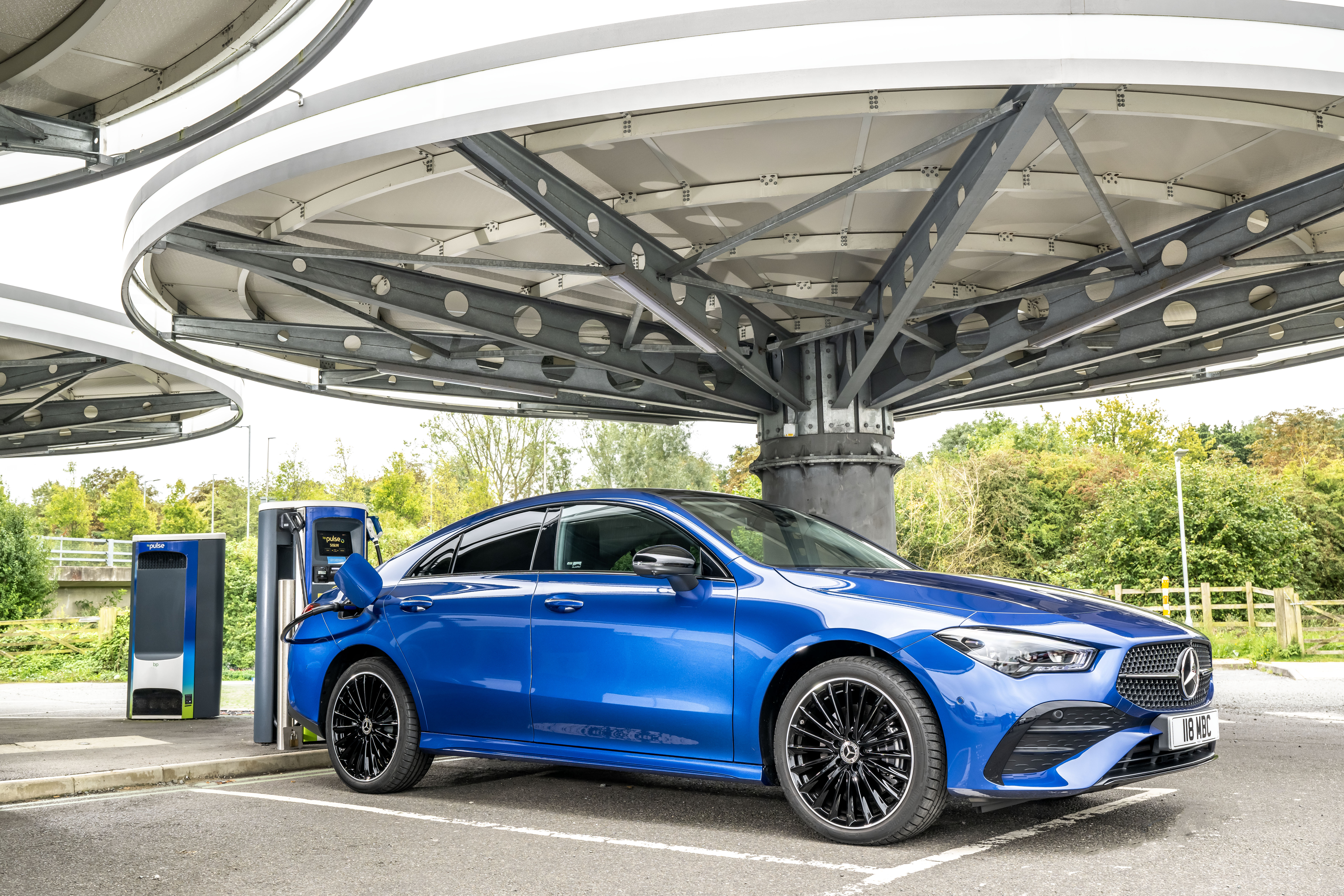 Blue Mercedes-Benz CLA 250 e AMG Line charging at an electric station.